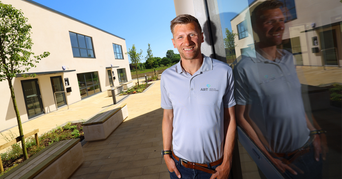 A photograph of a person standing next to a building