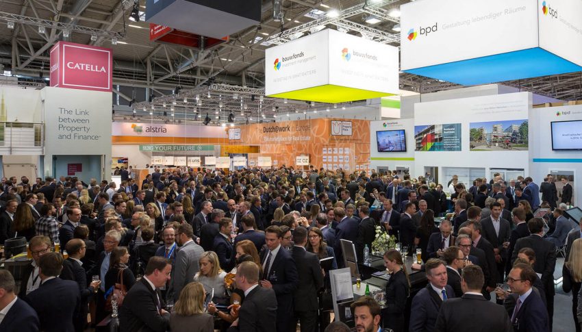 A photograph of a group of people conversing at the expo.