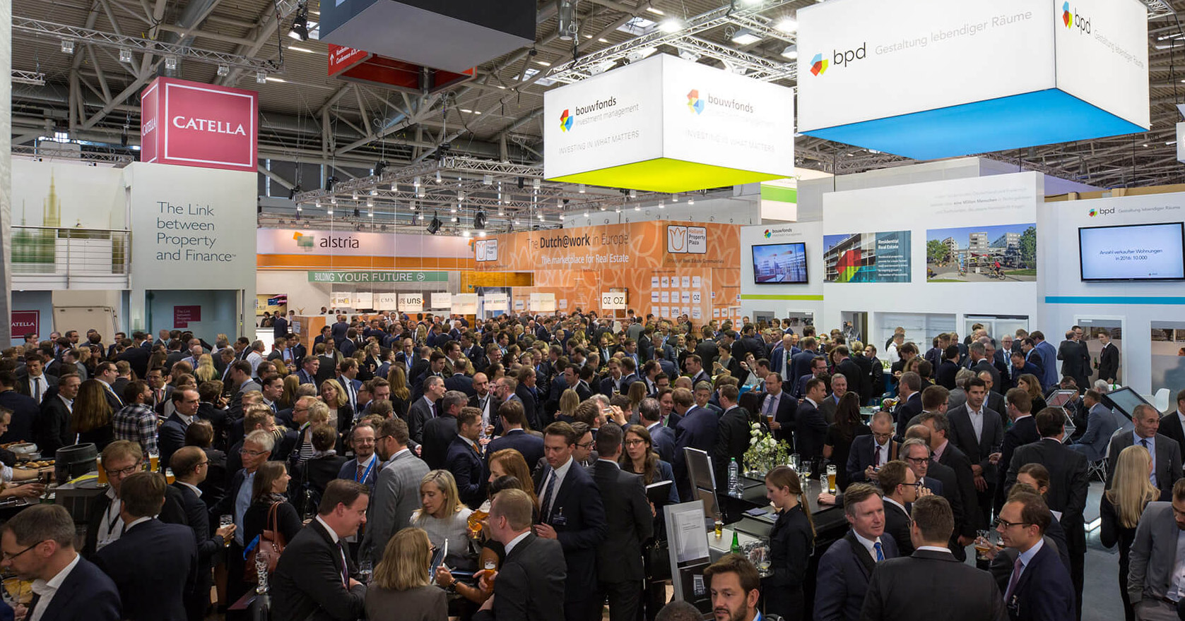 A photograph of a group of people conversing at the expo.