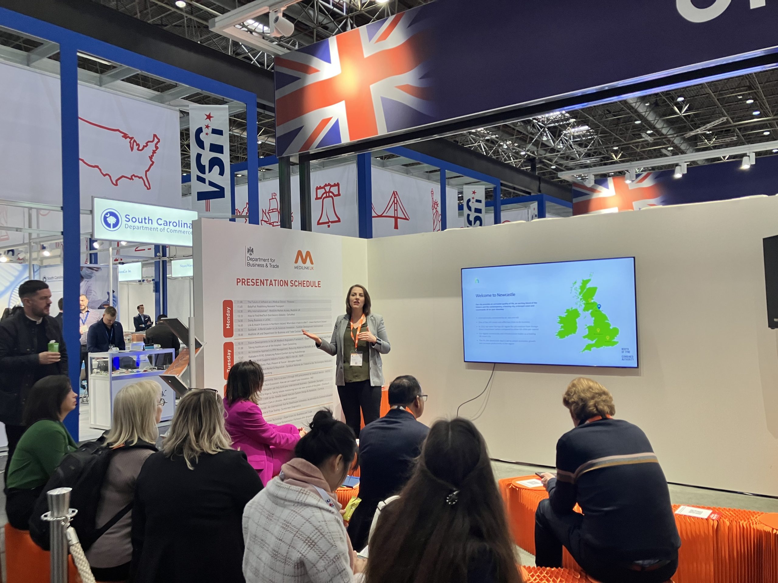 Becky presenting to small seated audience in the Medilink presentation area