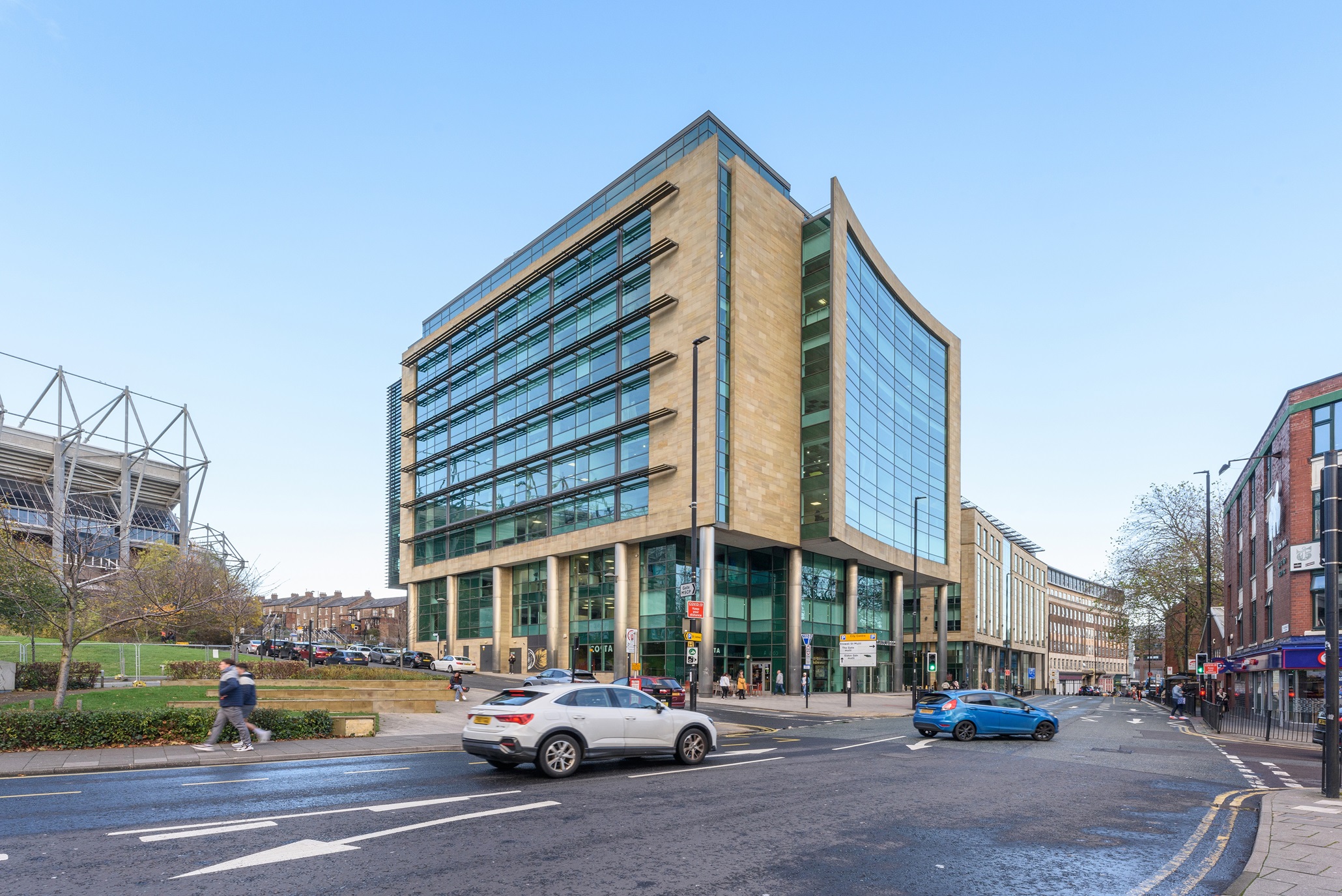 Wellbar Central office building stood next to St James' Park with cars and people passing underneath.