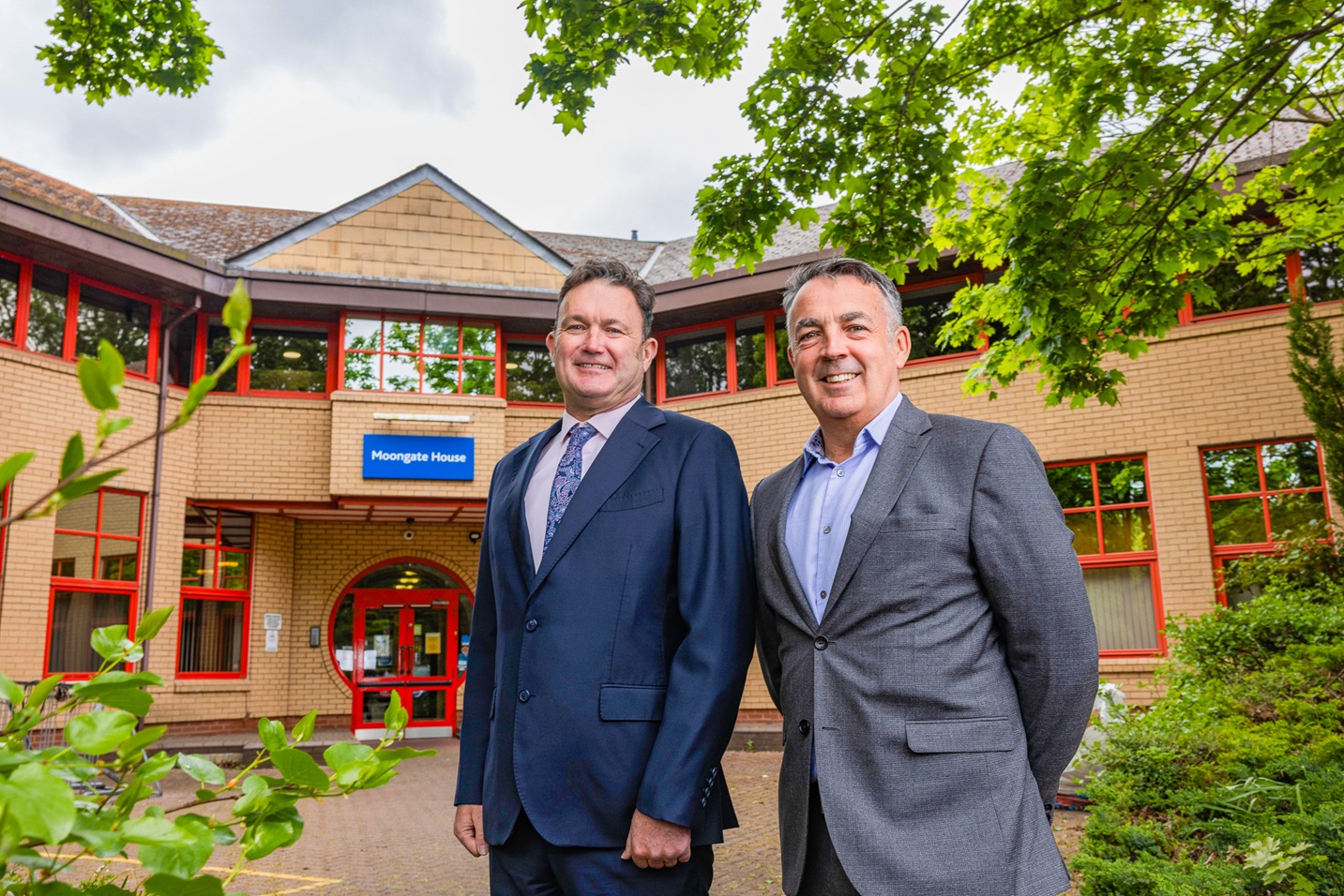 Antony and Paul wearing suits stood outside of Southbay's new headquarters.
