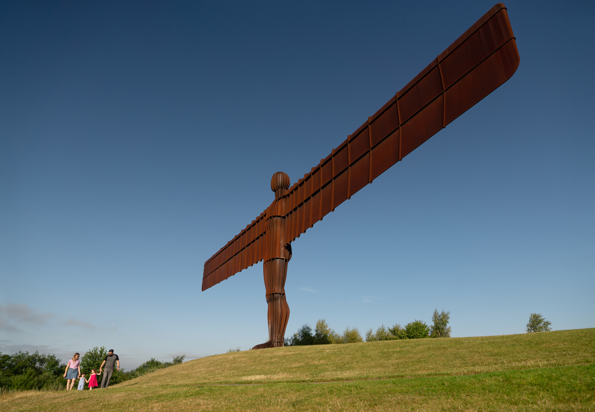Angel of the North statute on the top of a hill in the sunshine.