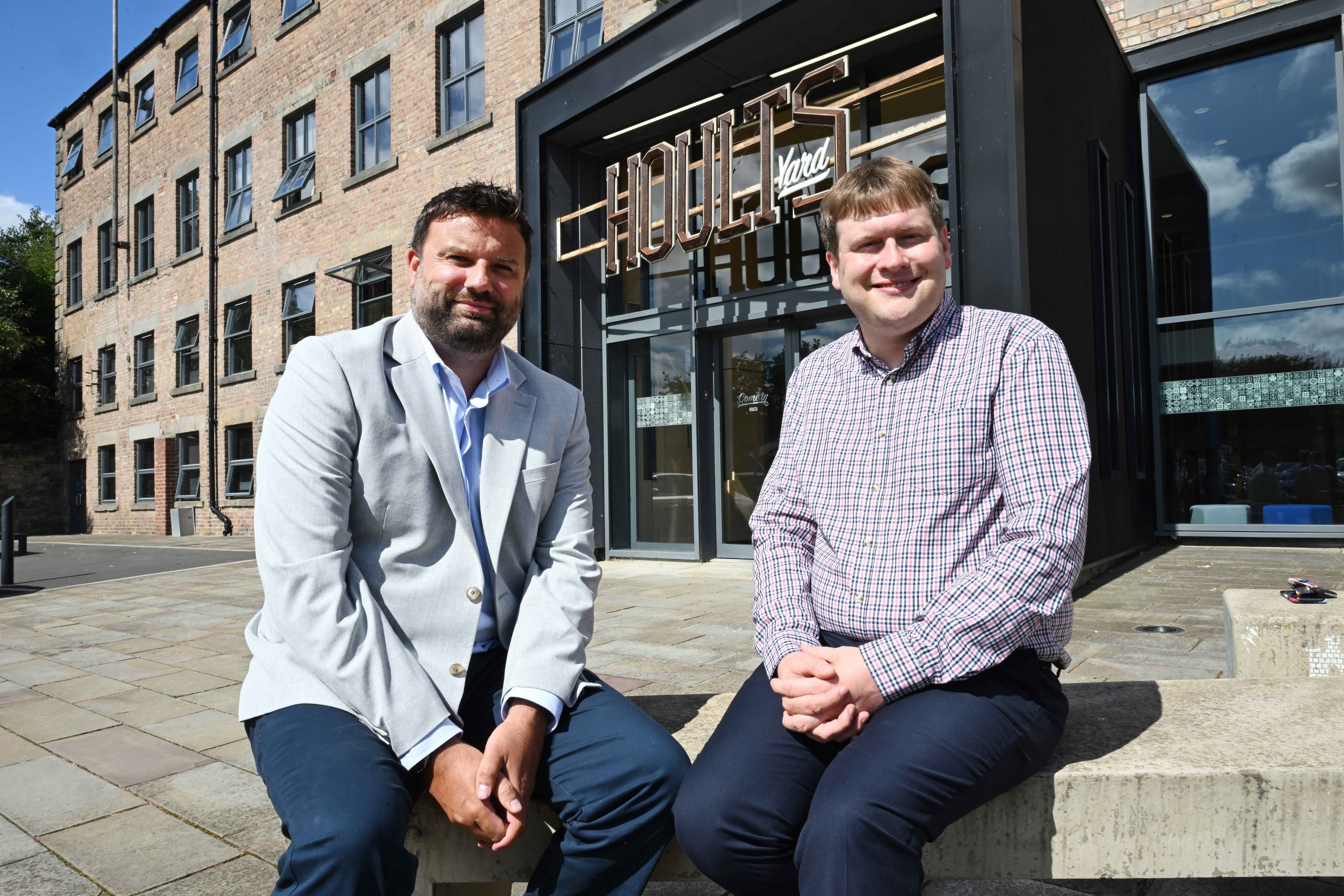 Cllr Alex Hay and Warren Whitfield sat outside of Hoults Yard office building in the sun.