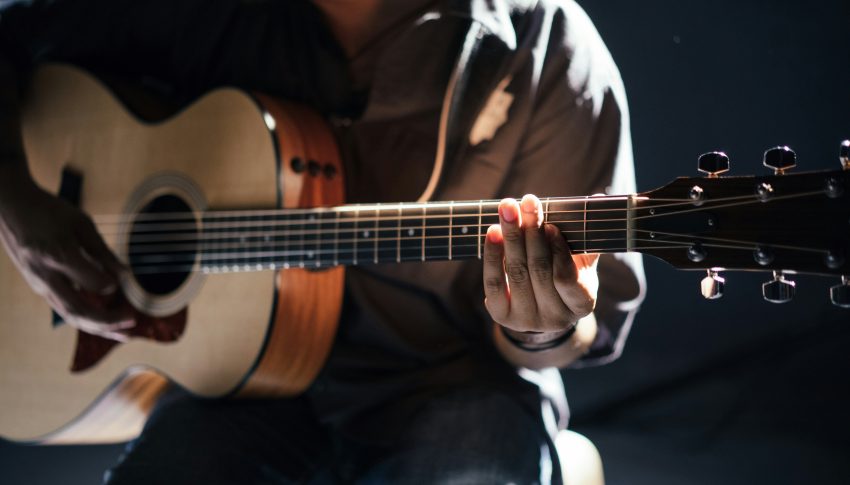 Person playing acoustic guitar