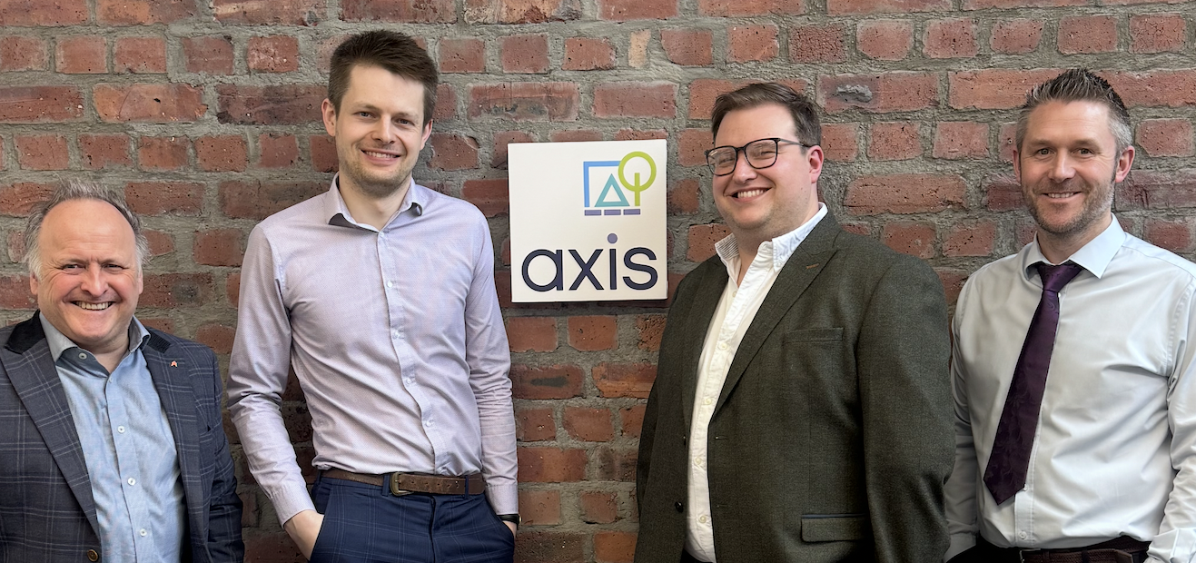 Four Axis Newcastle staff standing against brick wall with Axis branded sign in the middle.